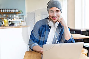 Young man using laptop at cafe