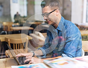 Young man using laptop at cafe