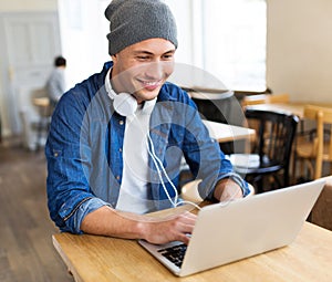 Young man using laptop at cafe