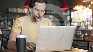 Young man using laptop computer in cafe