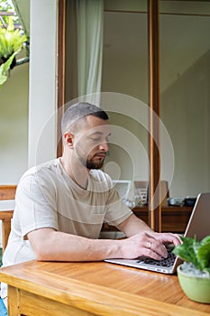 Young man using a laptop computer in a garden . business, study, freelance.