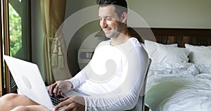 Young Man Using Laptop Computer Happy Smiling Guy Chatting Online Over Big Window With Tropical Garden View