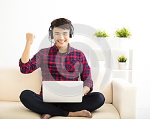 young man using laptop computer with headset