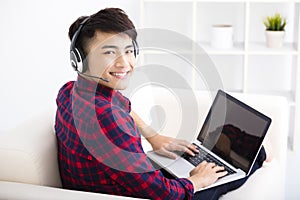 young man using laptop computer with headset