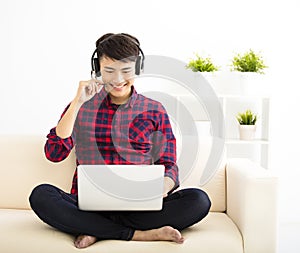 young man using laptop computer with headset photo