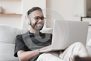 Young man using laptop computer at home, Student men resting in his room, working from home, online meeting concept