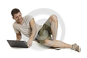 Young man using laptop computer smiling