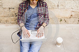 Young man using laptop and headphones