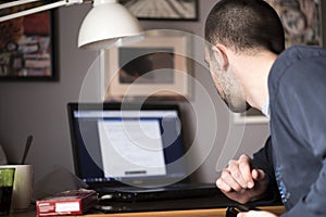 Young man using a laptop in his study room