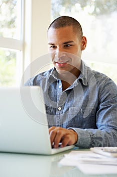 Young Man Using Laptop At Home