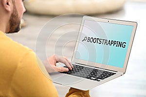 Young man using laptop at home. Bootstrap button photo