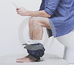 Young man using laptop on toilet.