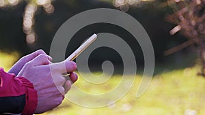 Young Man using a Mobile Phone on a Bench in the City Park