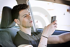 Young Man using mobile phone while driving