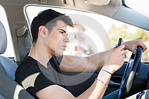 Young Man using mobile phone while driving