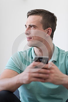 Young man using a mobile phone at home