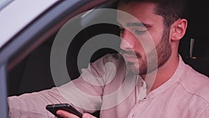 Young Man using mobile phone sitting in car