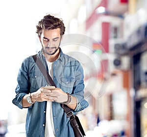 Young man using mobile phone in street