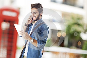 Young man using mobile phone in street