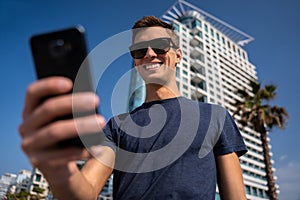 Young man using the phone. City Skyline In Background