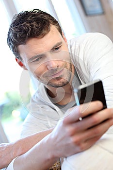 Young man using phone sending message