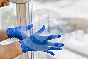 Young man is using a rag and squeegee while cleaning windows.