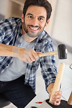 young man using repair tools to build new furniture