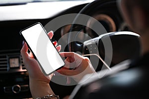 Young man using smart phone mobile phone in car. Close up view.