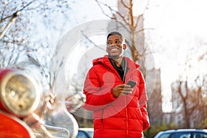 Young man using smart phone outdoors at urban setting