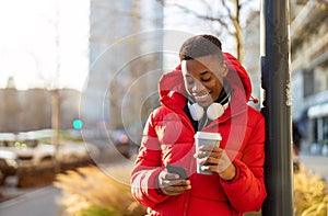 Young man using smart phone outdoors at urban setting