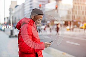 Young man using smart phone outdoors at urban setting