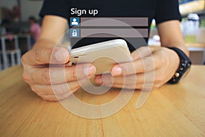 Young man using smart phone and sign up or log in username password on the wooden table in restaurant, GDPR.cyber security and