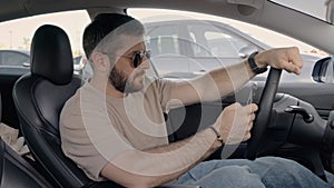 Young man using smartphone while driving a car