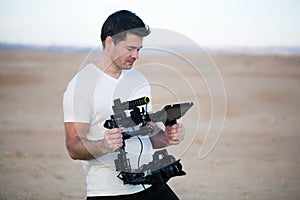 Young man using steadycam for shooting on beach