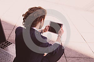 Young man using tablet computer on street. Internet