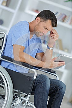 Young man using tablet in wheelchair