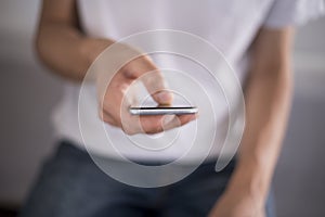 Young man using touchscreen smartphone. Concept for using technology, shopping online, using mobile apps, texting, phone addiction