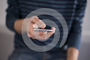 Young man using touchscreen smartphone. Concept for using technology, shopping online, using mobile apps, texting, phone addiction