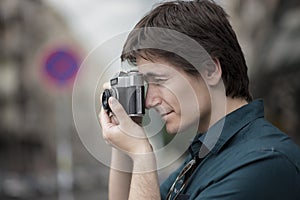 Young man using vintage film camera