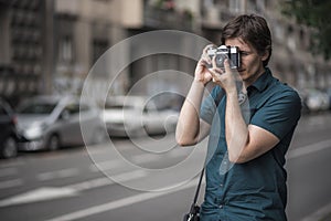 Young man using vintage film camera