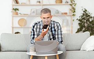 Young man using voice assistant on his smart phone