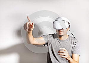 Young man using VR headset. Guy playing with VR glasses