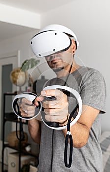 Young man using VR headset. Guy playing with VR glasses