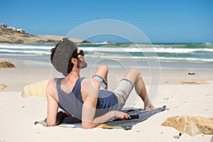 Young man on vacation sitting alone at a secluded beach photo