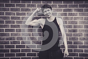 Young man in vest top flexing biceps