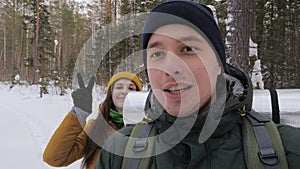 A young man, a video blogger, is recording a video in the forest with his girlfriend.