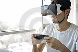 A young man vigorously plays a virtual reality video game wearing VR glasses. The man plays video games. Time relax.