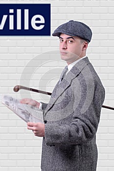 Young man in vintage clothes with hat, reading newspaper, 1940 s