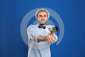 Young man with vintage video camera on background