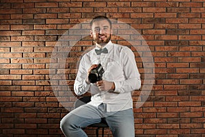 Young man with vintage video camera near wall